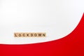 Wooden letters on a white and red background forming the word Ã¢â¬ÅlockdownÃ¢â¬Â. Second wave during Coronavirus pandemic concept Royalty Free Stock Photo